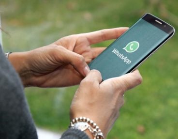 Frau, die WhatsApp am Telefon verwendet