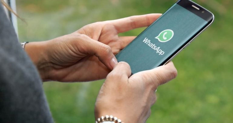 Frau, die WhatsApp am Telefon verwendet