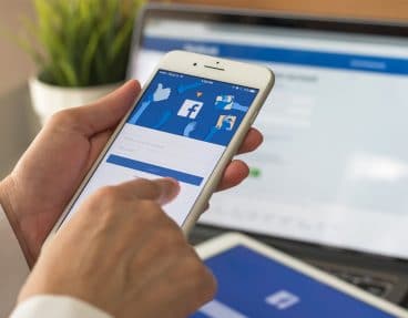 Person, die sich in der Facebook-App auf dem Handy anmeldet